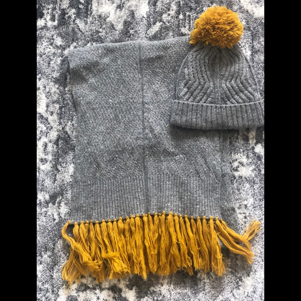 Matching winter hat and scarf.  Gray with mustard yellow pom pom and fringe.